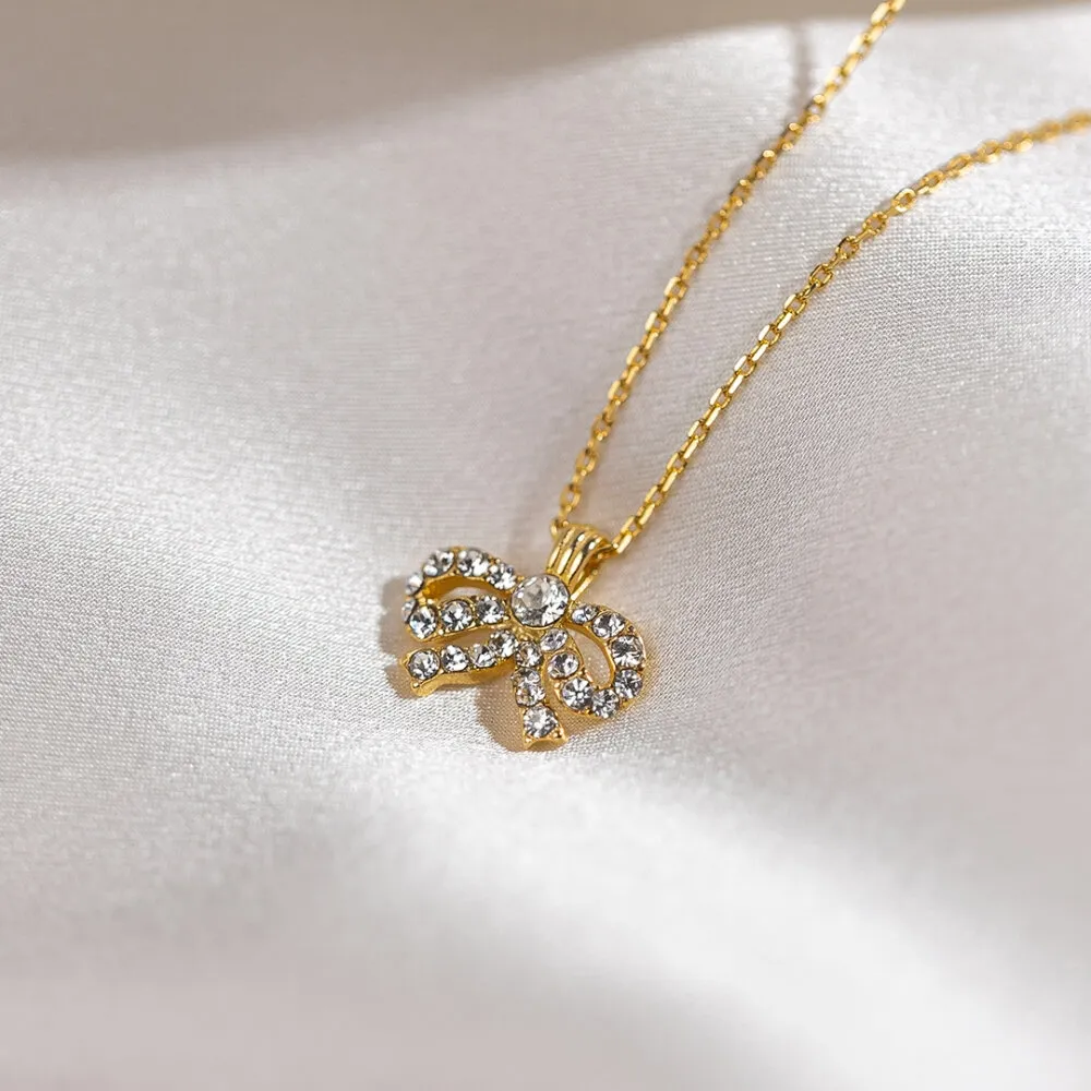 NÆRBILDE AV PETITE ANTOINETTE BOW NECKLACE GOLD PÅ HVIT BAKGRUNN